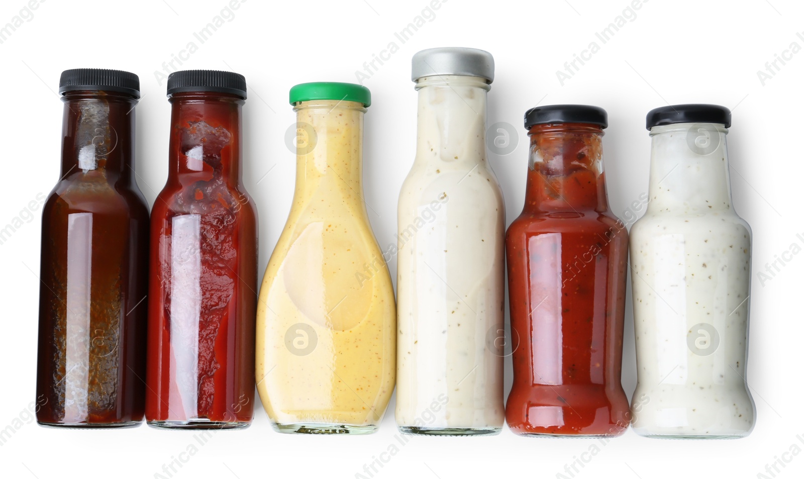 Photo of Different delicious sauces in glass bottles isolated on white, top view