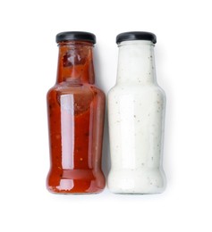 Photo of Different delicious sauces in glass bottles isolated on white, top view