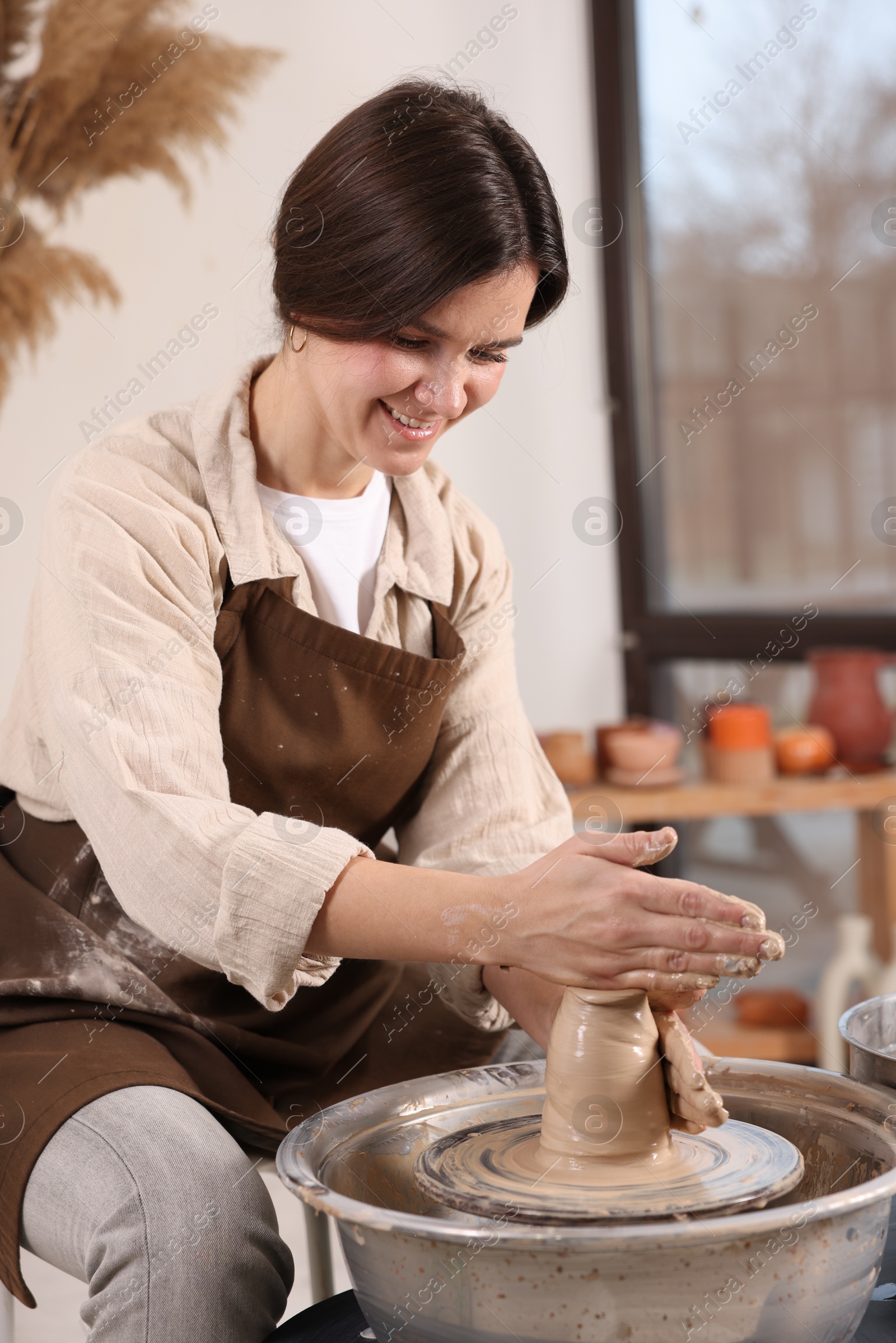 Photo of Hobby and craft. Smiling woman making pottery indoors