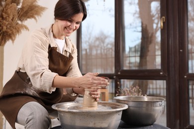 Photo of Hobby and craft. Smiling woman making pottery indoors