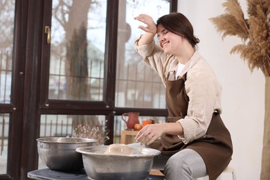 Photo of Hobby and craft. Smiling woman making pottery indoors