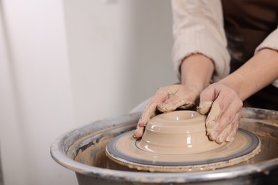 Photo of Hobby and craft. Woman making pottery indoors, closeup. Space for text