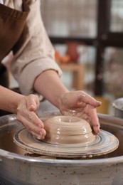 Photo of Hobby and craft. Woman making pottery indoors, closeup