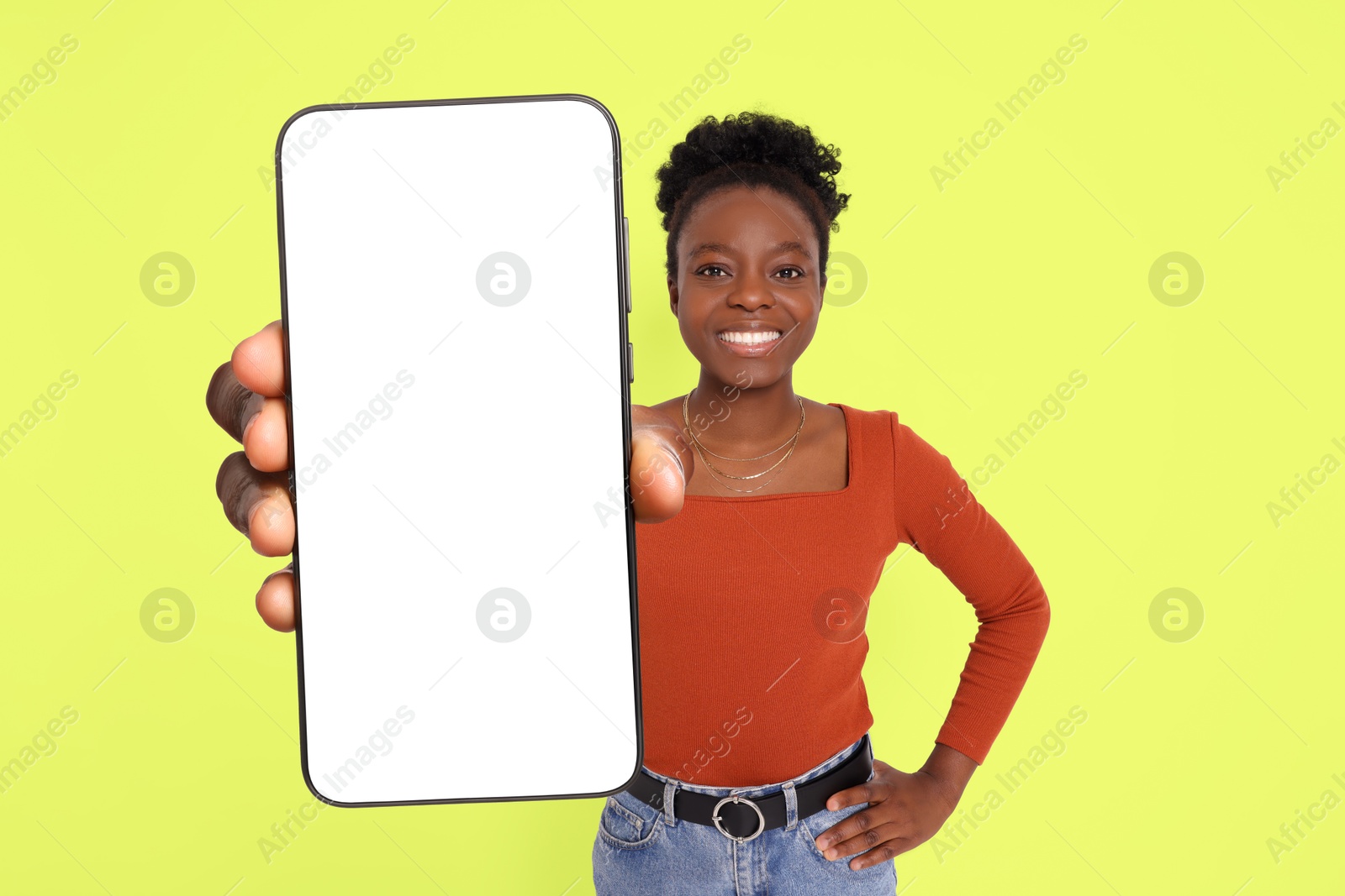 Image of Happy woman showing mobile phone with blank screen on greenish yellow background. Mockup for design