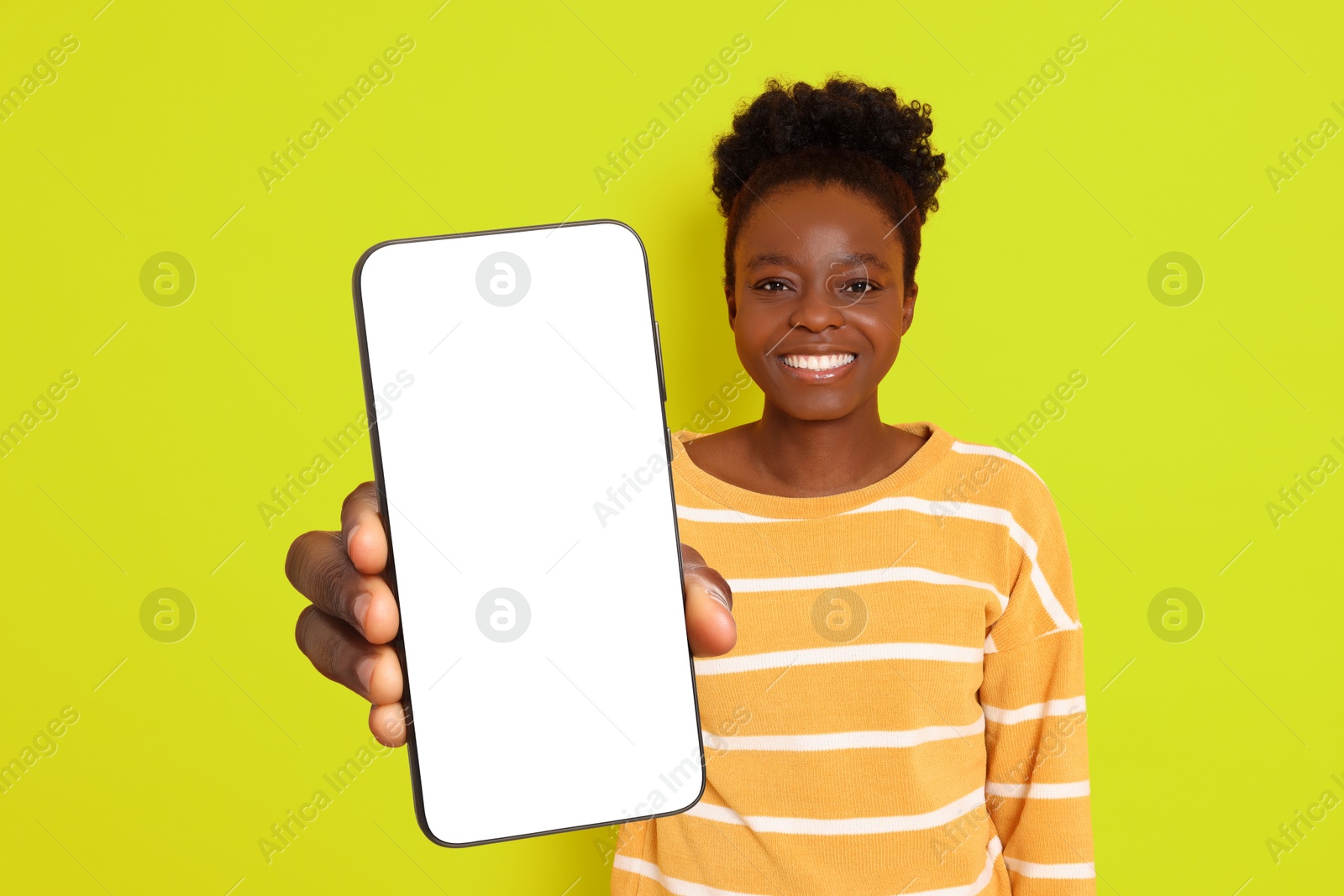 Image of Happy woman showing mobile phone with blank screen on greenish yellow background. Mockup for design