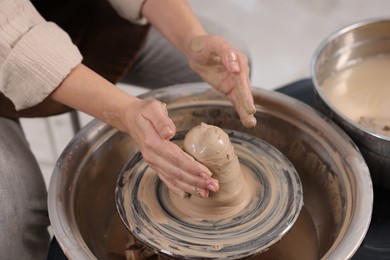 Photo of Hobby and craft. Woman making pottery indoors, closeup