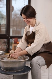 Hobby and craft. Smiling woman making pottery indoors