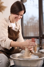 Photo of Hobby and craft. Smiling woman making pottery indoors