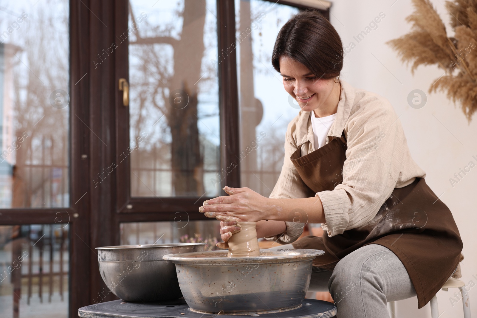 Photo of Hobby and craft. Smiling woman making pottery indoors