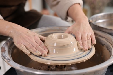 Photo of Hobby and craft. Woman making pottery indoors, closeup