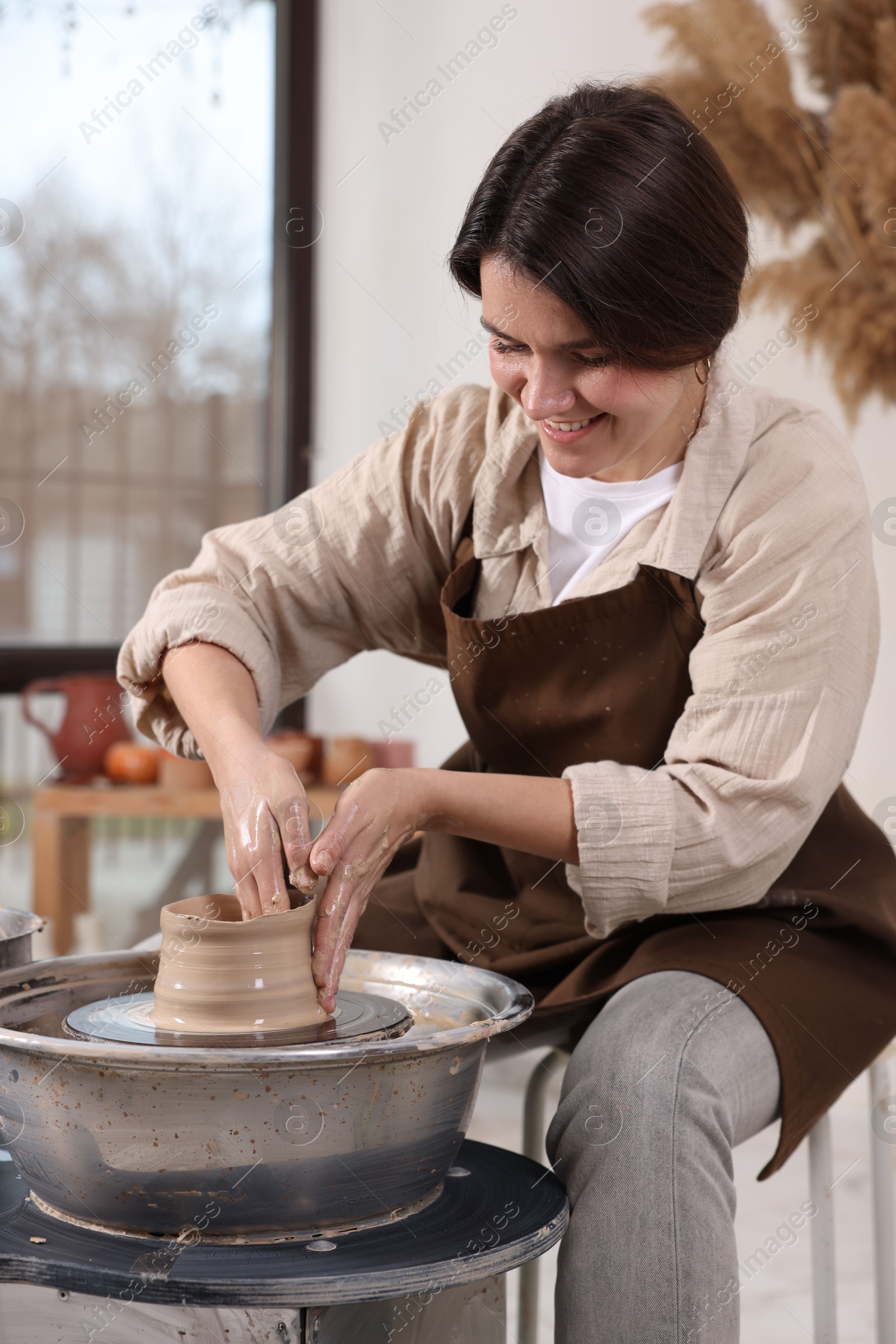 Photo of Hobby and craft. Smiling woman making pottery indoors