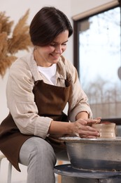 Photo of Hobby and craft. Smiling woman making pottery indoors