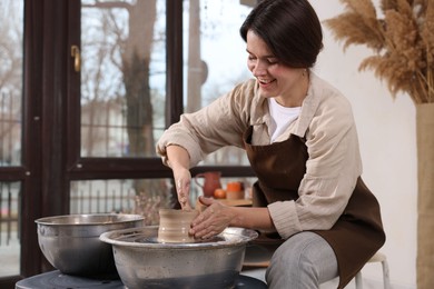 Photo of Hobby and craft. Smiling woman making pottery indoors