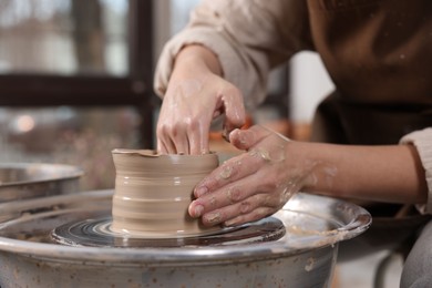 Photo of Hobby and craft. Woman making pottery indoors, closeup