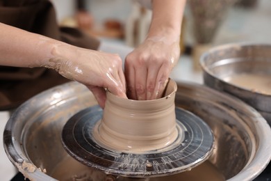 Photo of Hobby and craft. Woman making pottery indoors, closeup