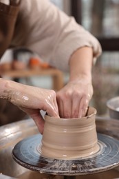 Photo of Hobby and craft. Woman making pottery indoors, closeup