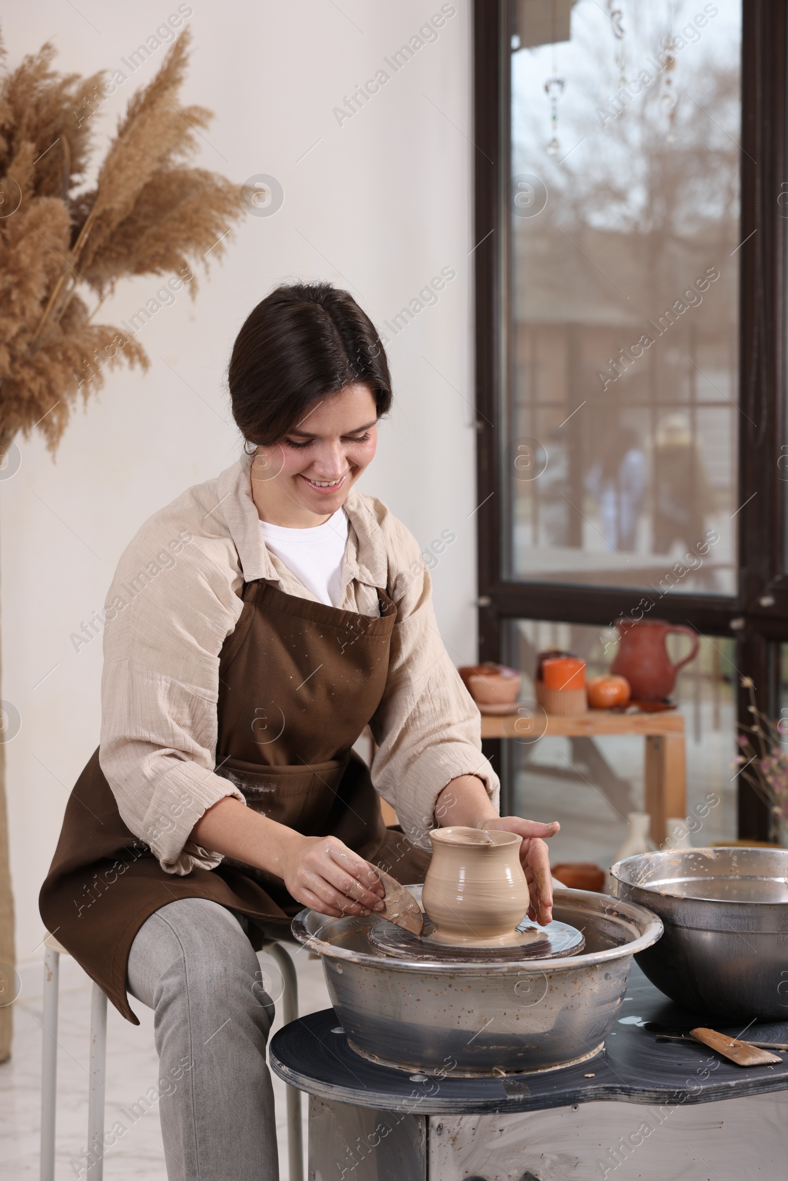 Photo of Hobby and craft. Smiling woman making pottery indoors