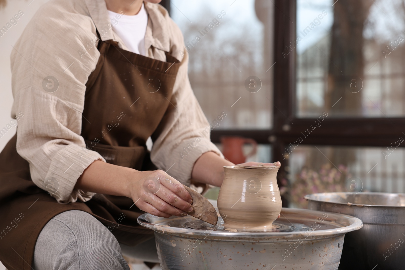 Photo of Hobby and craft. Woman making pottery indoors, closeup