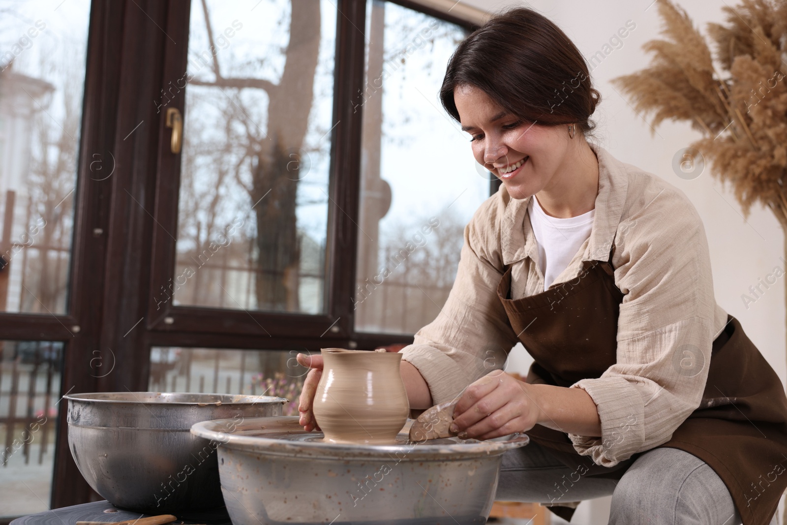 Photo of Hobby and craft. Smiling woman making pottery indoors