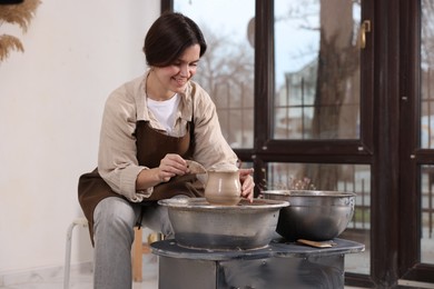 Photo of Hobby and craft. Smiling woman making pottery indoors