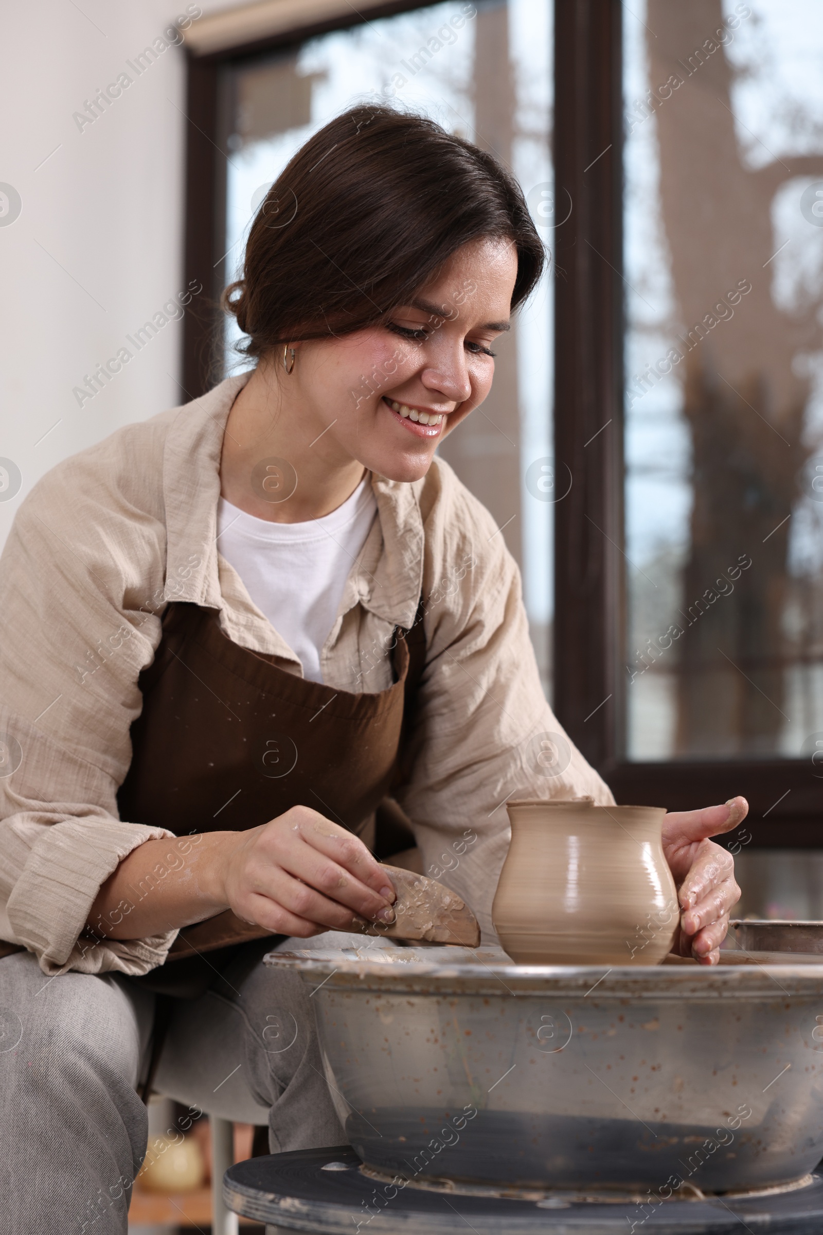 Photo of Hobby and craft. Smiling woman making pottery indoors