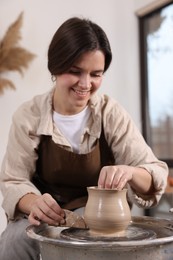 Photo of Hobby and craft. Smiling woman making pottery indoors