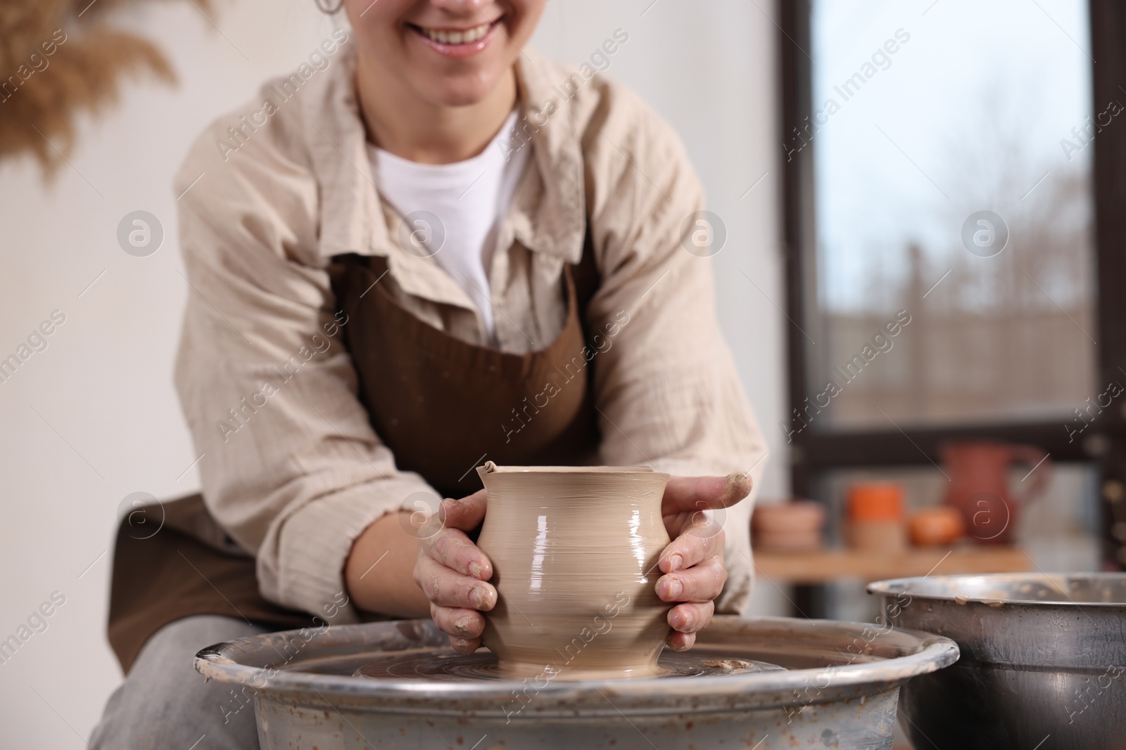 Photo of Hobby and craft. Woman making pottery indoors, closeup