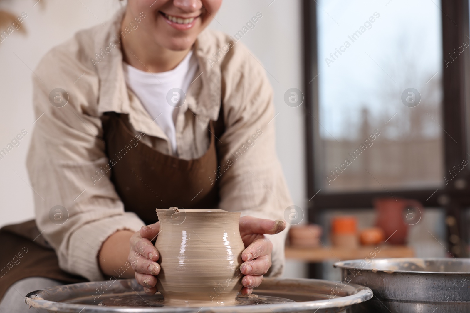 Photo of Hobby and craft. Woman making pottery indoors, closeup