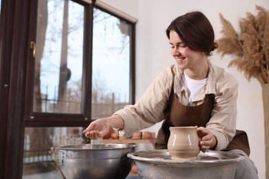 Photo of Hobby and craft. Smiling woman making pottery indoors