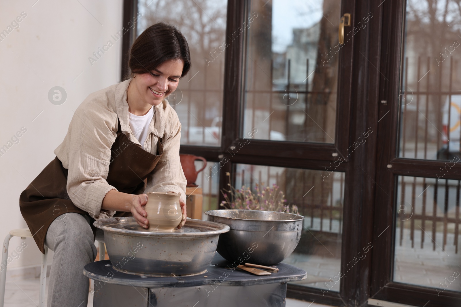 Photo of Hobby and craft. Smiling woman making pottery indoors