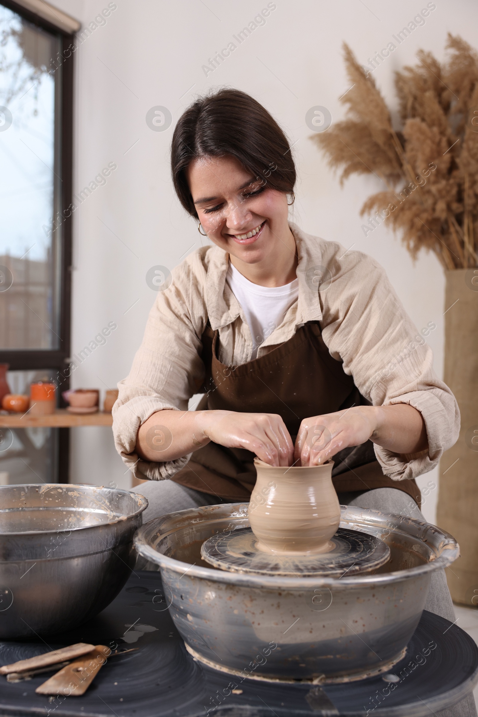 Photo of Hobby and craft. Smiling woman making pottery indoors