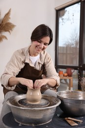 Photo of Hobby and craft. Smiling woman making pottery indoors