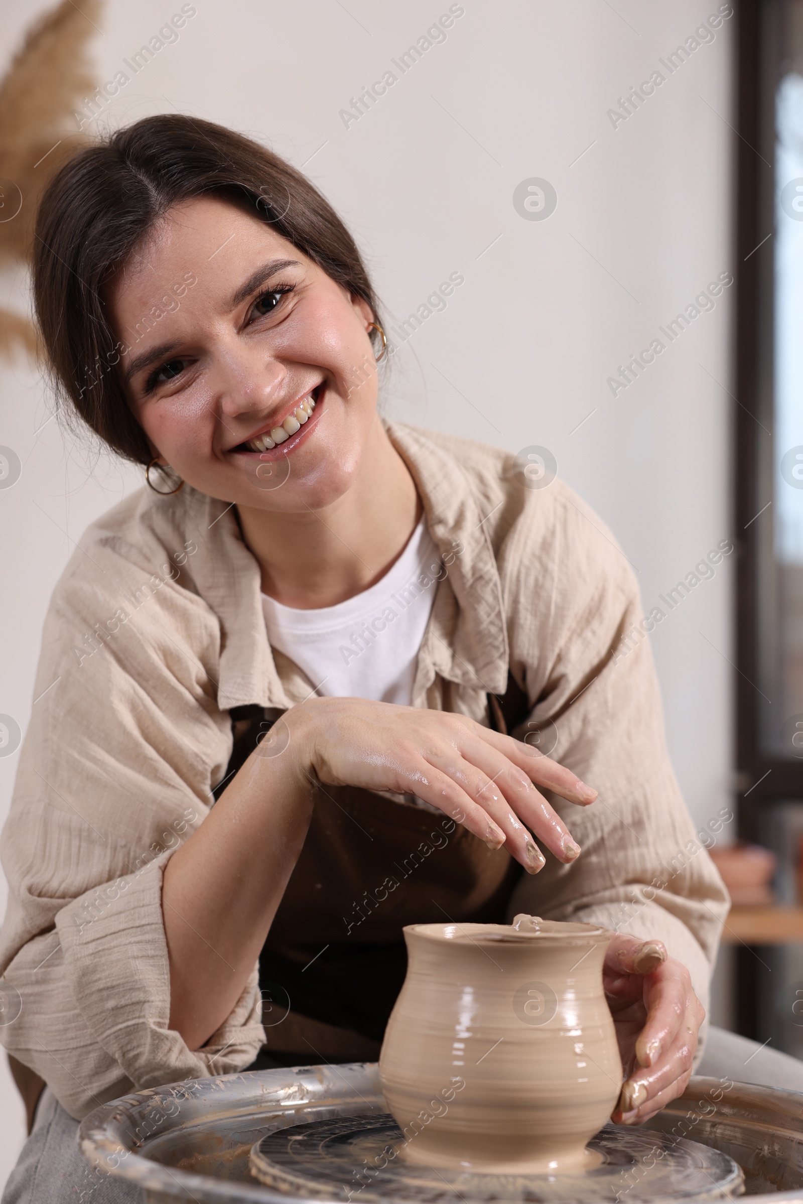 Photo of Hobby and craft. Smiling woman making pottery indoors