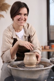 Photo of Hobby and craft. Smiling woman making pottery indoors