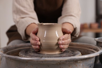 Photo of Hobby and craft. Woman making pottery indoors, closeup