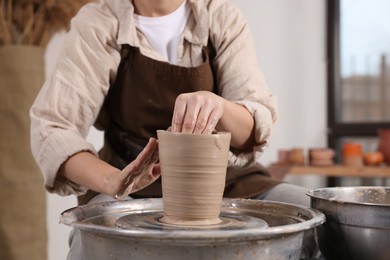 Photo of Hobby and craft. Woman making pottery indoors, closeup