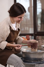 Photo of Hobby and craft. Smiling woman making pottery indoors