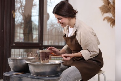 Photo of Hobby and craft. Smiling woman making pottery indoors