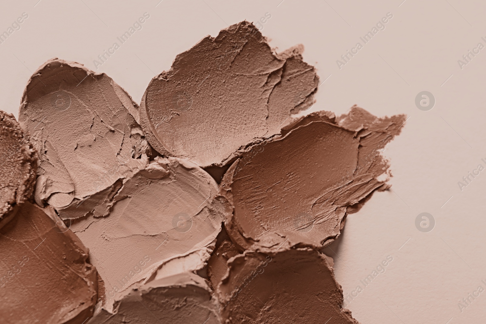 Image of Lipstick samples in mocha mousse shades on beige background, top view. Trendy color of 2025 year