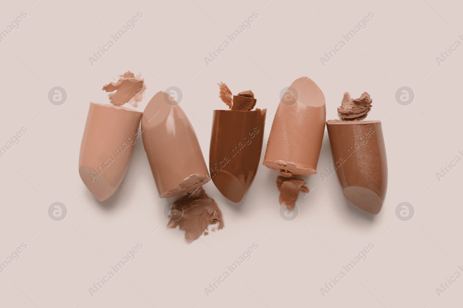 Image of Lipsticks in mocha mousse shades on beige background, top view. Trendy color of 2025 year