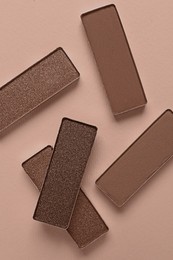 Image of Eyeshadows in mocha mousse shades on dark beige background, top view. Trendy color of 2025 year