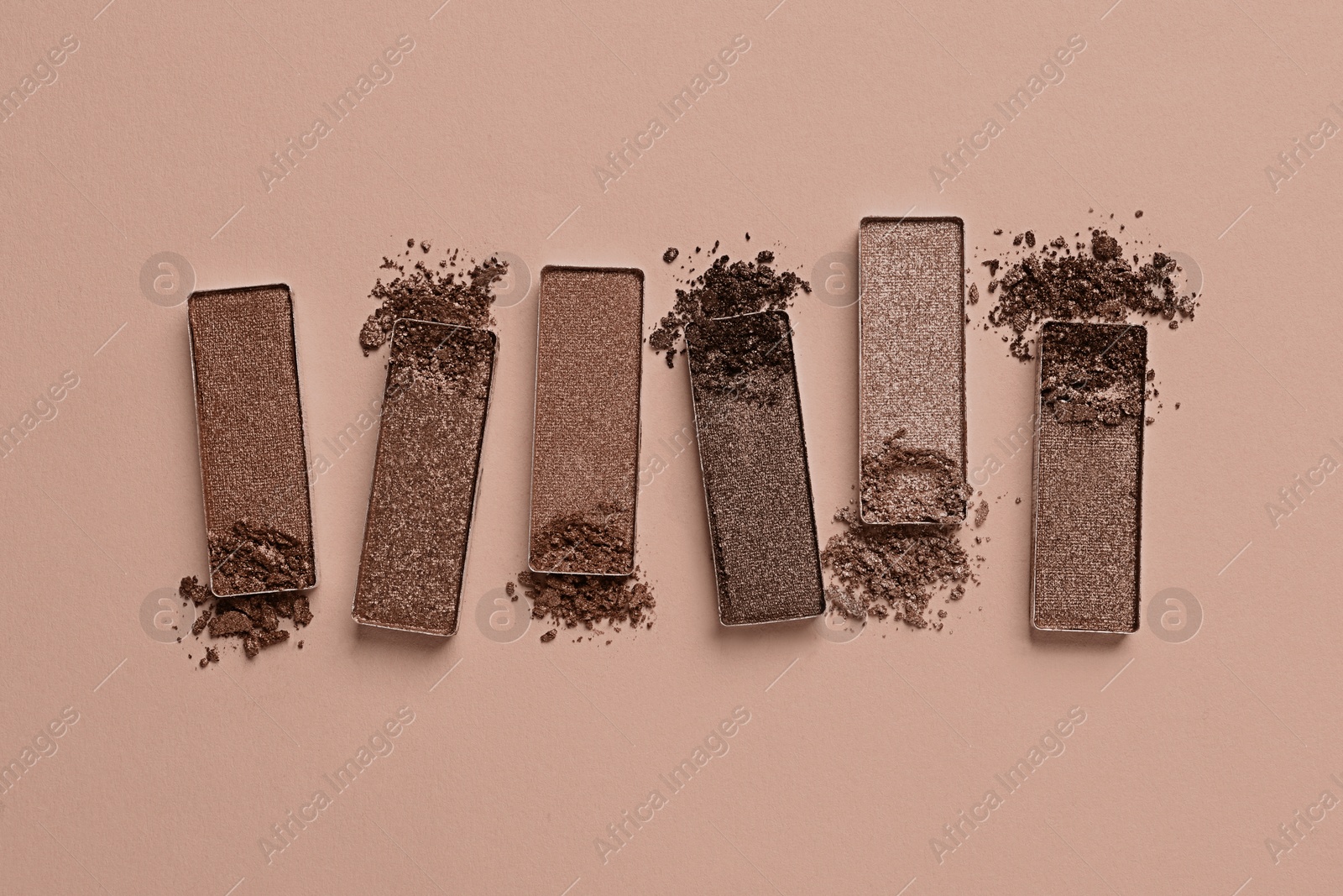 Image of Eyeshadows in mocha mousse shades on dark beige background, flat lay. Trendy color of 2025 year