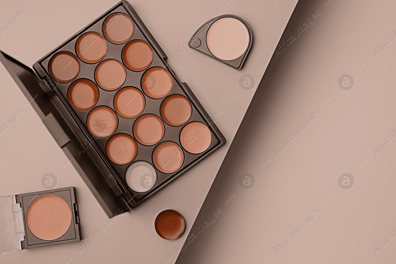 Image of Cream lipsticks in mocha mousse shades on beige background, flat lay. Trendy color of 2025 year