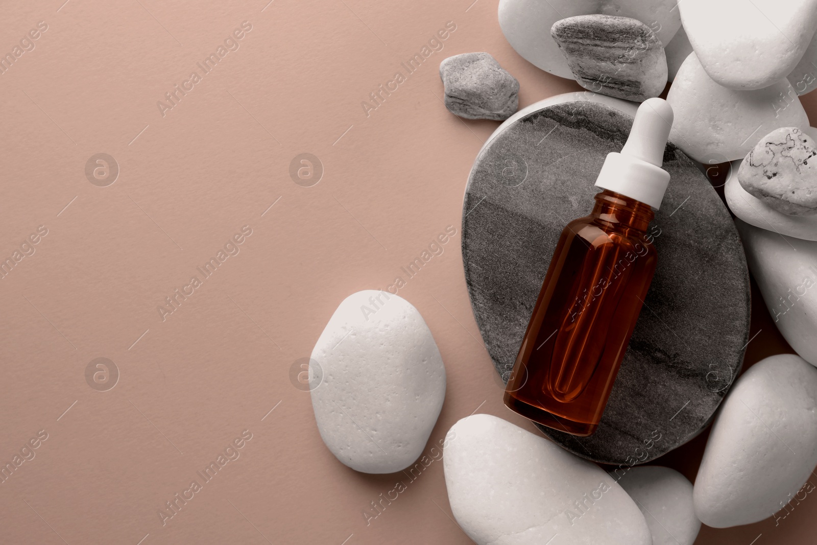 Image of Cosmetic serum and pebbles on mocha mousse shade background, top view. Trendy color of 2025 year