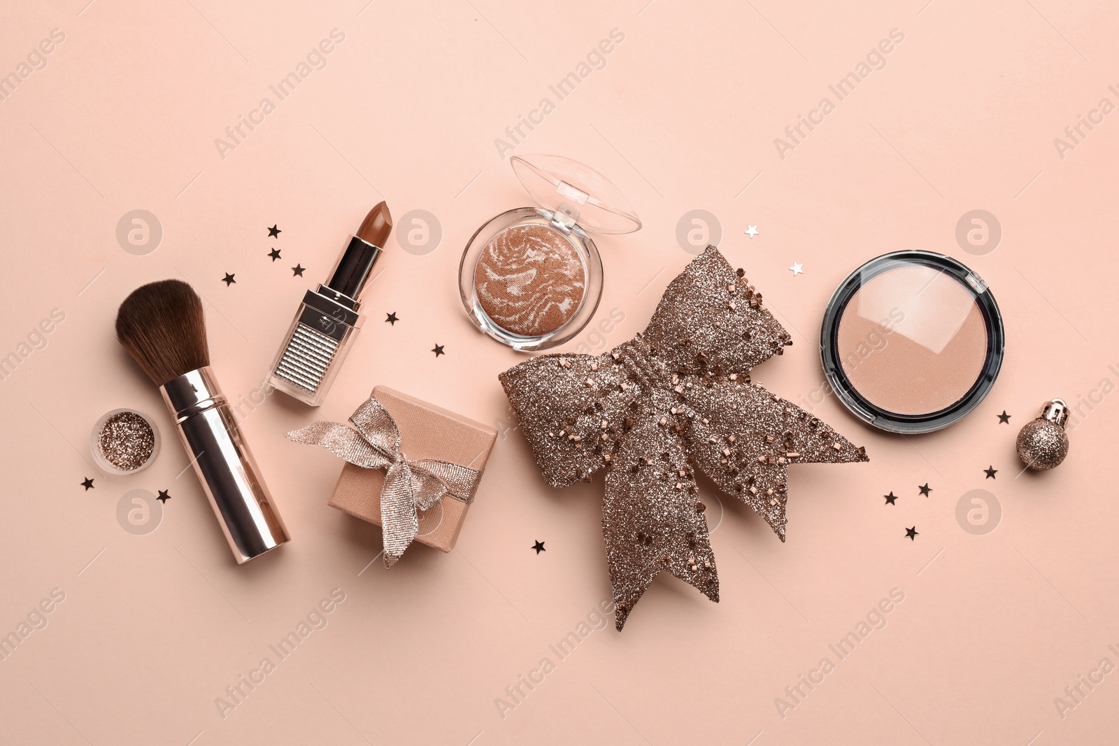 Image of Makeup products in mocha mousse shades, gift box and bow on beige background, top view. Trendy color of 2025 year