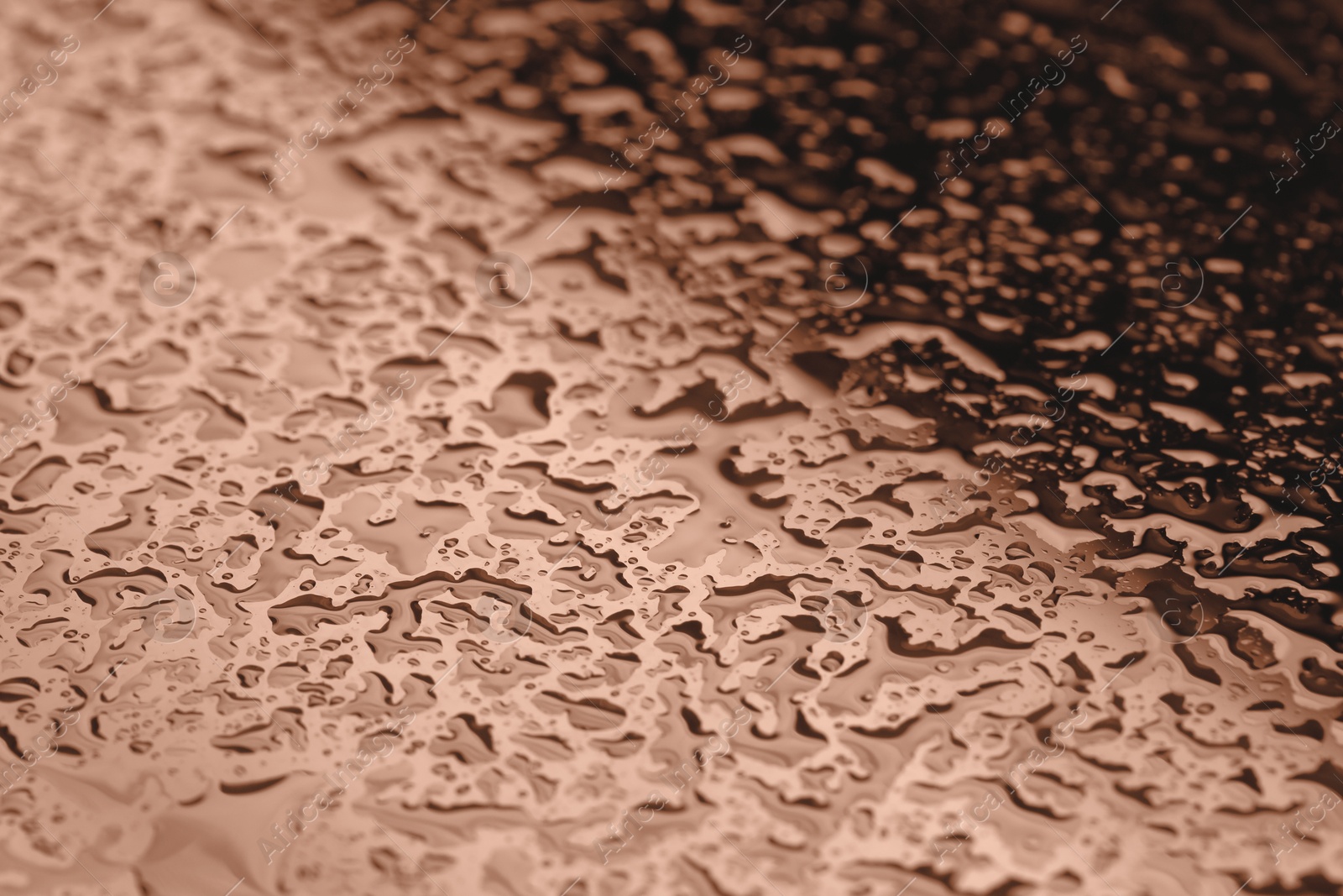 Image of Water drops on glass surface, closeup. Toned in trendy color of 2025 year - mocha mousse