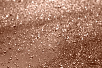 Image of Water drops on glass surface, closeup. Toned in trendy color of 2025 year - mocha mousse