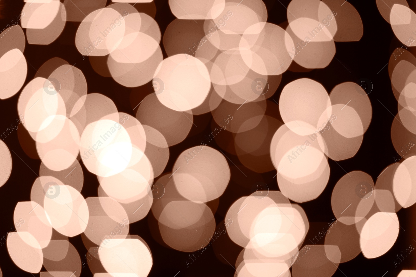 Image of Blurred bokeh lights toned in mocha mousse shade. Trendy color of 2025 year