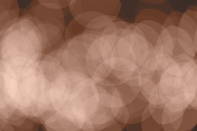 Image of Blurred bokeh lights toned in mocha mousse shade. Trendy color of 2025 year