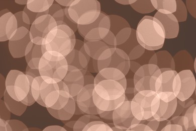 Image of Blurred bokeh lights toned in mocha mousse shade. Trendy color of 2025 year